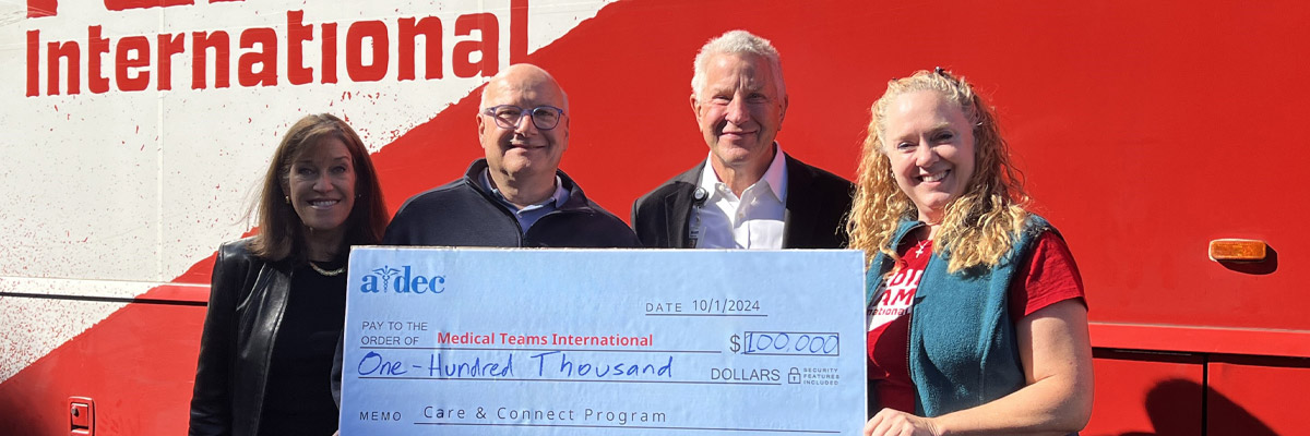 A-dec and Medical Teams International personnel post with a donation check