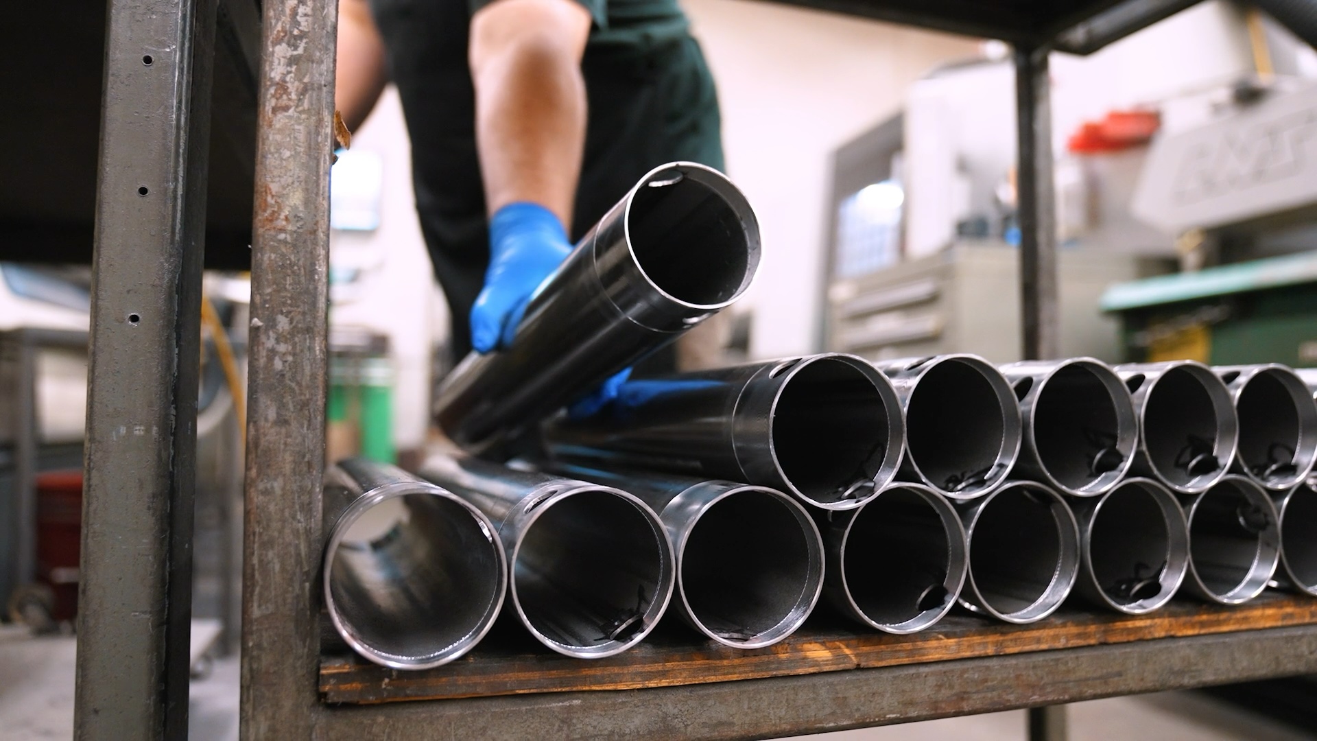 A-dec employee stacking long metal cylinders for dental equipment